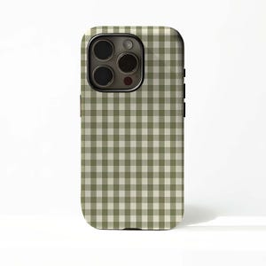 Può includere: Una custodia per telefono con un motivo a quadretti verde e bianco. La custodia ha un ritaglio per la fotocamera e pulsanti laterali neri. Il design è un motivo a quadretti classico, che offre un aspetto semplice ma elegante per un telefono cellulare.