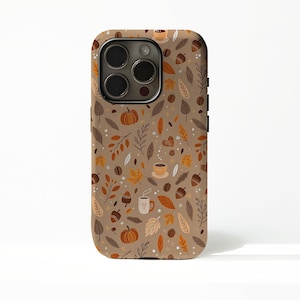 Può includere: Custodia per telefono con motivo autunnale. Il design presenta zucche, ghiande, tazze di caffè e foglie nei toni del marrone, arancione e beige. La custodia ha un modulo fotocamera nero e pulsanti laterali.