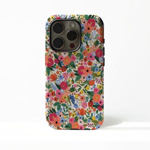 Può includere: Custodia per telefono con motivo floreale. Il motivo presenta fiori rosa, arancioni, gialli e blu con foglie verdi su sfondo bianco. Modulo fotocamera nero e pulsanti laterali neri.