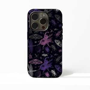 Peut inclure: Coque de téléphone noire avec un motif répété d'insectes violets, gris et blancs. Le motif comprend des coléoptères, des papillons, des libellules et des papillons de nuit. L'étui a une découpe pour l'appareil photo et des boutons sur le côté.