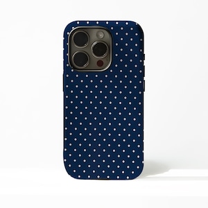 May include: A navy blue phone case with a white polka dot pattern. The case has a smooth finish and a camera cutout. The phone case is designed to fit a smartphone.