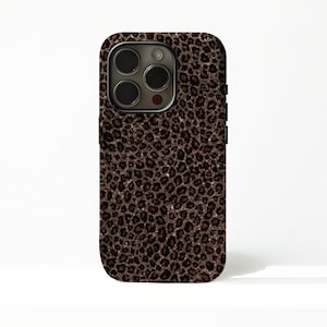 Puede incluir: Una funda para smartphone con un diseño de estampado de leopardo marrón. La funda tiene un borde negro y un recorte para la cámara. El patrón de leopardo está compuesto por pequeñas manchas marrones oscuras sobre un fondo marrón claro.