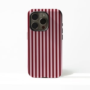 May include: A smartphone case featuring a vertical striped design in alternating pink and burgundy shades. The case has a glossy finish and a camera cutout on the upper left corner.