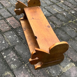 May include: A wooden shelf with two shelves, shaped like squirrels. The shelf is made of natural wood and has a rustic finish.