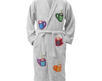 Puede incluir: Una bata de baño gris claro con mangas largas, cuello tipo chal y un cinturón a juego en la cintura. La prenda está decorada con motivos bordados de tazas de café coloridas en azul, verde, rojo y naranja, cada una con un remolino de vapor.