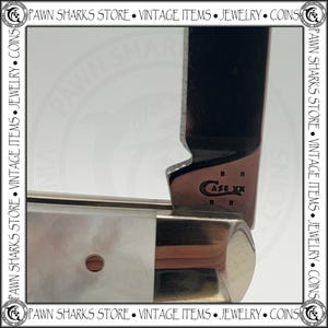 May include: A folding pocket knife featuring a polished metal blade and a handle with a pearlescent white finish. The blade is stamped with the text CASE XX and four small dots arranged in a square pattern near the bolster of the knife.