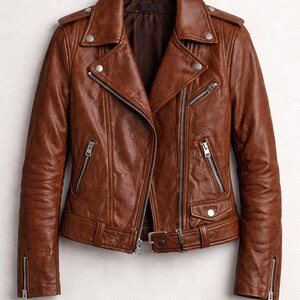 K&ouml;nnte beinhalten: Braune Lederjacke im klassischen Biker-Stil. Die Jacke hat einen Reverskragen, einen asymmetrischen Rei&szlig;verschluss, mehrere Rei&szlig;verschlusstaschen und silberfarbene Hardware. Die &Auml;rmel haben Rei&szlig;verschlussmanschetten und die Taille einen G&uuml;rtel mit Schnalle.