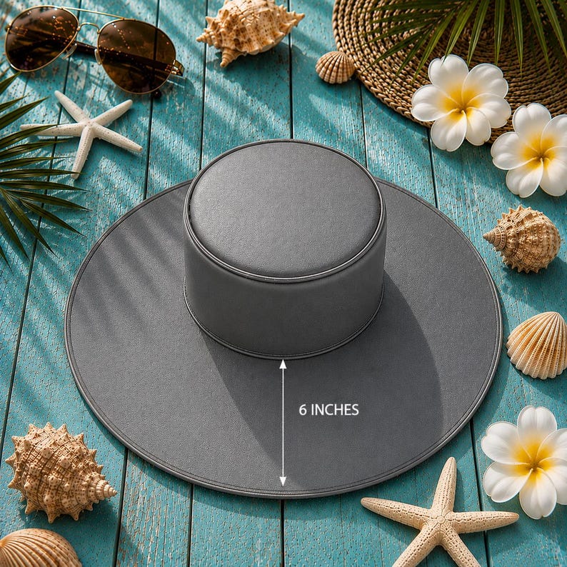 Puede incluir: Sombrero gris con ala de 15 cm, exhibido con conchas marinas, gafas de sol y flores tropicales. El sombrero tiene un dise&ntilde;o sencillo, ideal para la protecci&oacute;n solar.