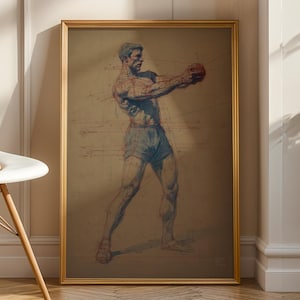 Op de afbeelding: Een ingelijste vintage print van een bokser in actie, in bruin-, blauw- en roodtinten. Het kunstwerk toont een gespierde figuur die een bal vasthoudt, tegen een neutrale achtergrond. De gouden lijst voegt een klassieke touch toe.