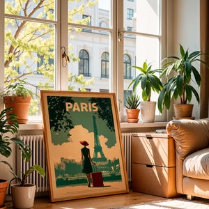 May include: A framed travel poster with the word "PARIS" at the top. The poster depicts a person with a red hat and suitcase in front of the Eiffel Tower. The poster is in a room with plants, a window, and a sofa.