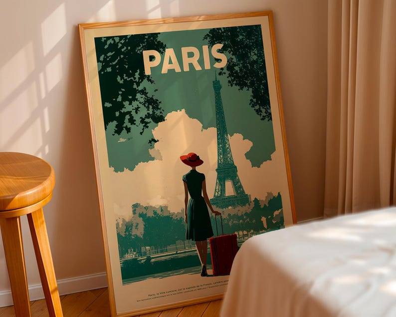 May include: A framed travel poster with the word "PARIS" at the top. The poster depicts a woman in a red hat and dress, with a suitcase, walking towards the Eiffel Tower. The poster has a vintage travel theme.