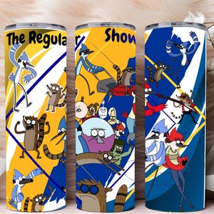 May include: Three stainless steel tumblers with cartoon character designs. Each tumbler features a different background color: yellow, blue, and white. The text "The Regular Show" is visible on the first tumbler. The tumblers are decorated with cartoon characters.