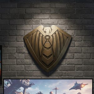 Pode incluir: Um escudo de cor bronze com um emblema de &aacute;guia e detalhes de estrela, montado em uma parede de tijolos. O escudo tem uma superf&iacute;cie texturizada e um design estilizado. Abaixo do escudo, uma tela exibe uma cena de cidade futurista com ve&iacute;culos voadores.