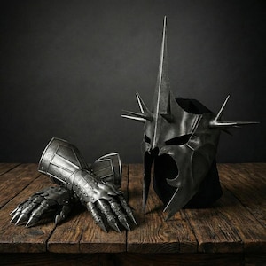 May include: A dark metal helmet with a central spike and smaller spikes, and a pair of matching gauntlets. The helmet and gauntlets are displayed on a wooden surface against a dark background.