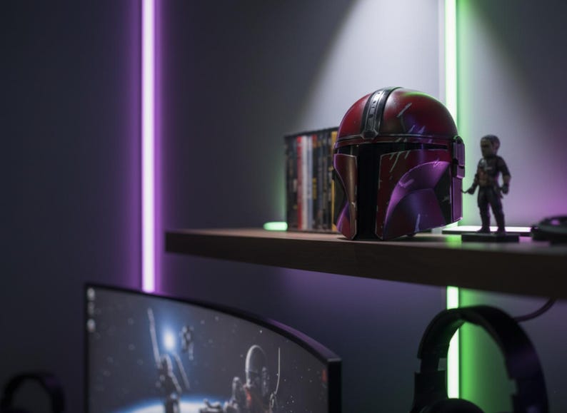 May include: A shelf displays a red and purple Mandalorian helmet, a small figurine, and a stack of DVDs. The helmet is the focal point, with a weathered appearance. The scene is illuminated by purple and green neon lights.