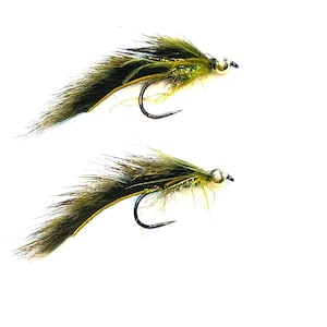 May include: Two fishing flies with black hooks and olive green and brown feathered bodies. The flies have a silver bead head and are set against a white background. These flies are designed for fly fishing.