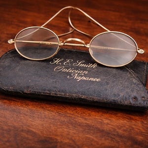 Gafas ópticas americanas Prefex antiguas con estuche H.E. Smith Napanee, principios del siglo XX, montura de alambre bañada en oro, estilo victoriano.