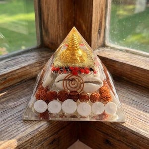 Spiritual pyramid with golden Buddha statue, shell and energy layers.