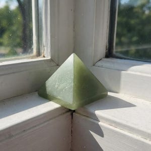 Sacred geometry green aventurine pyramid crystal used for meditation and chakra healing
