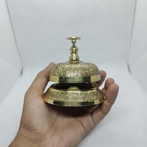 Brass table bell with classic design and loud clear tone, ideal for restaurant service use or vintage themed home decor.