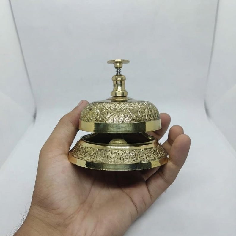 Brass table bell with classic design and loud clear tone, ideal for restaurant service use or vintage themed home decor.