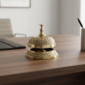 Classic brass service bell featuring push button mechanism and decorative detailing, ideal reception counter bell for hotel lobby or front desk.