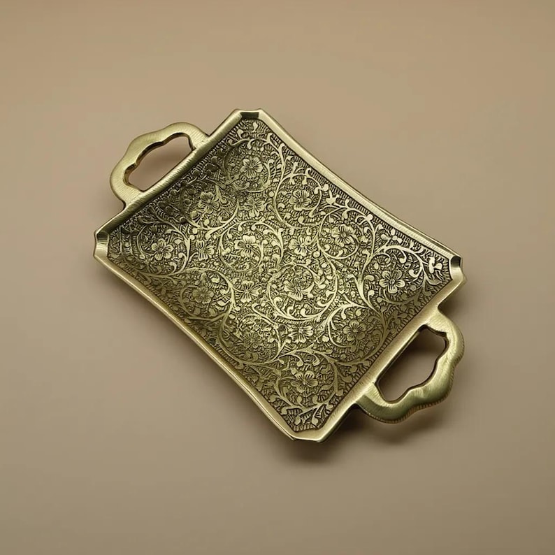 Decorative gold metal tray with ornate floral detailing