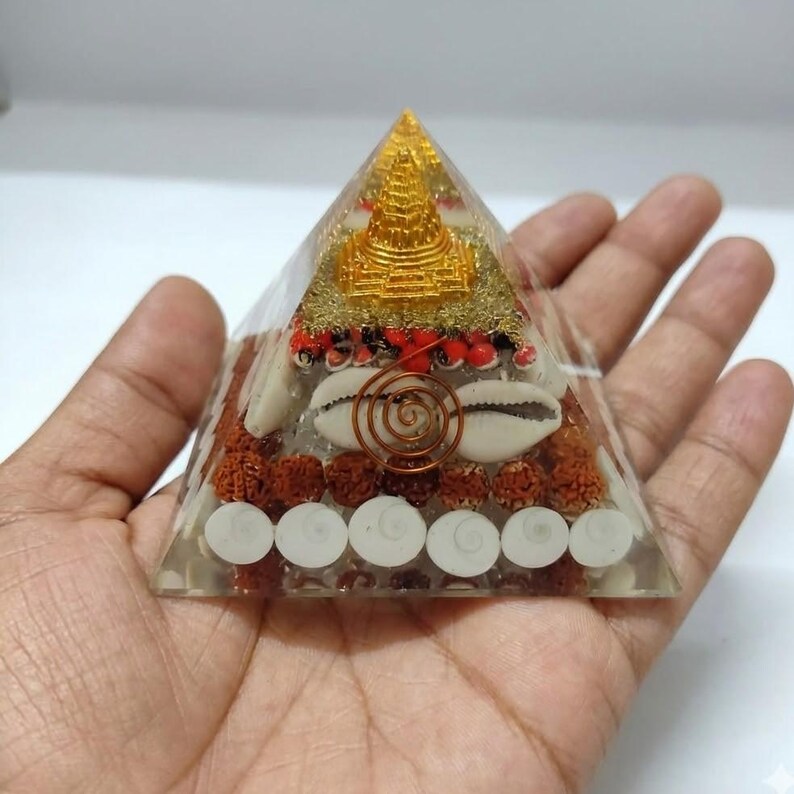 Energy cleansing pyramid decorated with rudraksha and Buddha design.