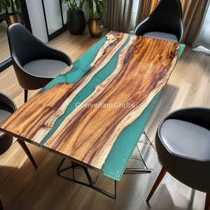 Può includere: Un tavolo rettangolare in legno con un design a fiume in resina epossidica turchese. Il tavolo ha un motivo a venature naturali e è circondato da sedie nere. Il testo "ConvenantCrafts" è visibile sul tavolo.
