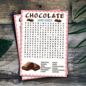 Könnte beinhalten: Zwei rosa umrandete Wortsuchrätsel mit dem Wort „CHOCOLATE“ oben. Die Rätsel zeigen ein Buchstabenraster und eine Liste von Wörtern zum Thema Schokolade. Der Hintergrund ist eine Holzoberfläche mit einem grünen Blatt und Palmfarnen.