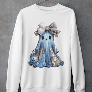 Könnte beinhalten: Weißes Sweatshirt mit einer Aquarellillustration eines Geistes in einem blauen Laken, einer gemusterten Schleife und einem kürbisförmigen Süßigkeiteneimer. Der Geist hat zwei schwarze Augen und einen gemusterten Rock. Das Sweatshirt hängt an einem kupferfarbenen Kleiderbügel.