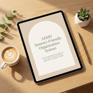 Peut inclure: Une tablette numérique affichant le texte "ADHD Sensory-Friendly Organization System", avec une tasse de café, une plante succulente, un stylo et une branche d'eucalyptus sur une surface en bois. L'écran de la tablette présente un design en arche beige.