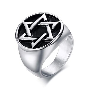 Puede incluir: Anillo plateado con un diseño de pentagrama prominente dentro de un marco circular. El anillo tiene un acabado pulido y una banda ancha, creando un accesorio audaz y llamativo. El pentagrama es una estrella de cinco puntas, un símbolo asociado a creencias esotéricas.
