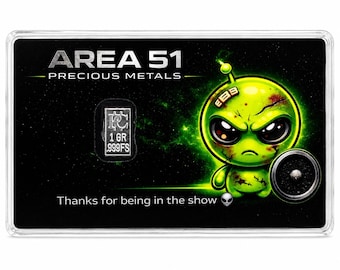 May include: A rectangular black display card titled AREA 51 PRECIOUS METALS featuring a green alien illustration, a small silver 1 gram .999FS bullion bar, and the text Thanks for being in the show with a small alien emoji icon.