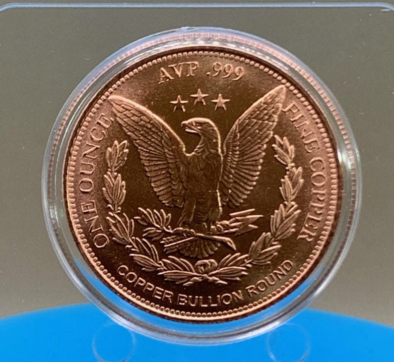 Straight-on view of the copper round's reverse side, featuring the eagle-and-wreath "Copper Bullion Round" design in a protective capsule