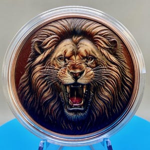 Colorized roaring lion 5 oz copper round in a clear acrylic capsule, high relief mane and open jaws