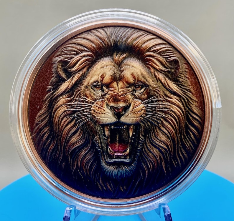 Colorized roaring lion 5 oz copper round in a clear acrylic capsule, high relief mane and open jaws