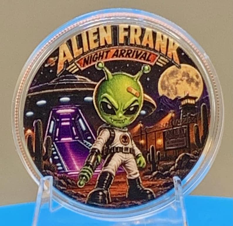 Front of the Night Arrival 1 oz copper round in a clear capsule: a colorized green alien with a bandage on his head, in a white spacesuit, stands before a landed UFO with a glowing purple ramp under a full moon, with "Alien Frank Night Arrival" lettering