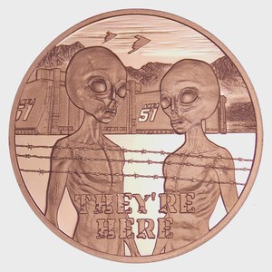 May include: A copper-colored round coin featuring two alien figures with large eyes, standing behind barbed wire. The background includes Area 51 buildings and the text "THEY'RE HERE". Two flying saucers are also visible.