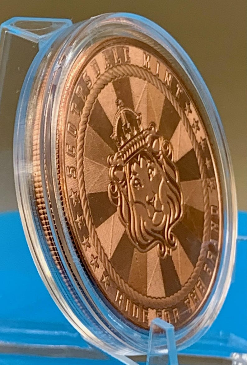 Reverse side of the 5 oz .999 fine copper Cowboy round, featuring a Scottsdale Mint lion crest emblem with the motto "Ride for the Brand" on a radiating sunburst background.