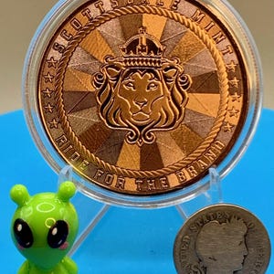 5 oz copper round with Scottsdale Mint lion crest reverse design and the motto "Ride for the Brand," shown with a small toy figure and a coin for size reference.