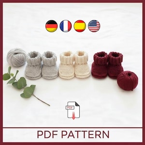 May include: A collection of crocheted baby booties in various colors: gray, cream, and burgundy. A ball of gray yarn and a ball of burgundy yarn are also present. The image includes the text "PDF PATTERN".