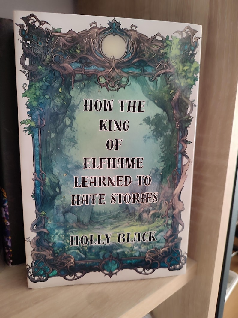May include: A hardcover book titled "HOW THE KING OF ELFHAME LEARNED TO HATE STORIES" by Holly Black. The cover features a fantasy illustration with a forest scene in shades of blue, green, and white, framed by ornate, dark green and blue foliage.