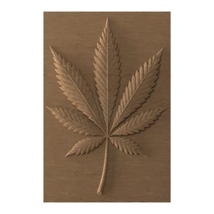 May include: A detailed, three-dimensional carving of a cannabis leaf. The leaf is a light brown colour and is set against a darker brown, wood-grain background. The carving highlights the leaf's veins and serrated edges.