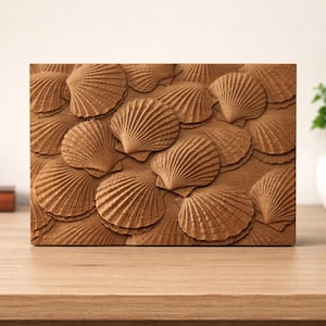 May include: A rectangular wooden artwork featuring a repeating pattern of detailed, three-dimensional seashells. The shells are a warm, natural brown colour, creating a textured, tactile appearance. The artwork is displayed on a wooden surface.