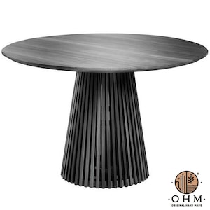 Puede incluir: Una mesa redonda de color gris oscuro con una superficie circular lisa y una base de pedestal construida con numerosas láminas verticales delgadas dispuestas en forma cónica. El logotipo en la esquina muestra un icono circular y el texto OHM ORIGINAL HAND MADE.