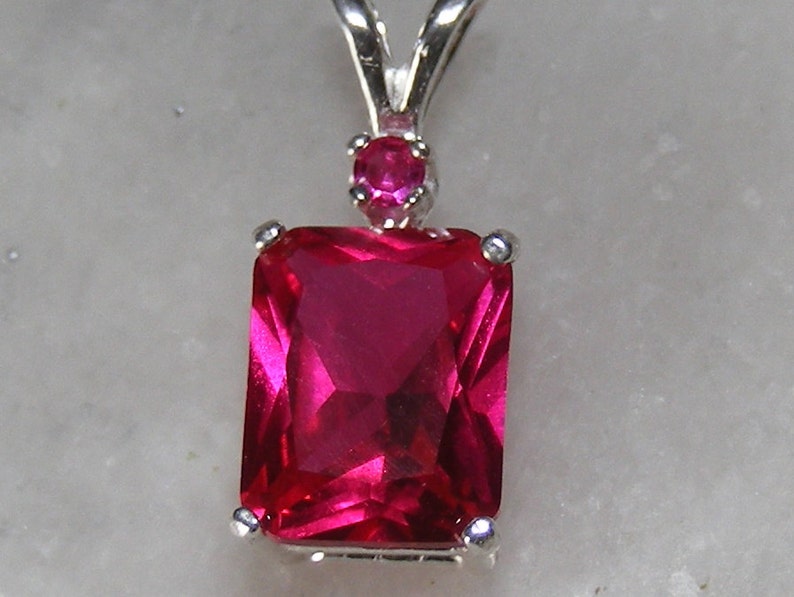 Ruby pendant with ruby accent mounted in silver.9x7 image 1