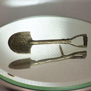Grubby shovel tie tack.