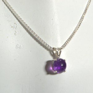 May include: A silver chain necklace with a round, purple amethyst pendant.