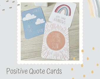 May include: Three positive quote cards with colourful illustrations. The first card is blue with white clouds and rain drops and says "Dance in the rain". The second card has a rainbow and says "Let's chase rainbows". The third card has a sun and says "Shine like the sun".